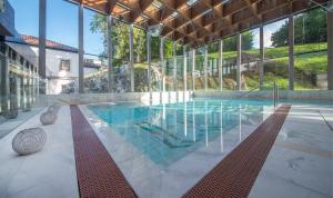 a large swimming pool in a building with glass walls at Gran Hotel Las Caldas by blau hotels in Las Caldas