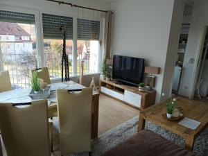 a living room with a television and a table with chairs at Wie Daheim in Nürnberg