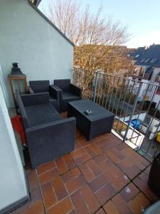 eine Terrasse mit 2 Sofas und einem Tisch auf dem Balkon in der Unterkunft Wie Daheim in Nürnberg