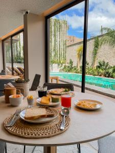 a table with food on it with a view of a pool at Tintto Hotel in Fortaleza