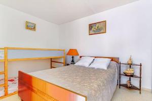 ein Schlafzimmer mit einem großen Bett in einem Zimmer in der Unterkunft Appart Familial Le Grau Du Roi in Le Grau-du-Roi