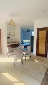 Il comprend un salon avec une table et des chaises ainsi qu'une cuisine. dans l'établissement Luana suites- Suite Nikté, à Zihuatanejo