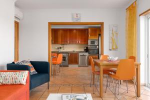 sala de estar y cocina con mesa y sillas en Two Bedroom Apartment in Fuzeta by Ideal Homes, en Olhão
