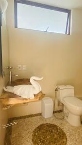 a bathroom with a toilet and a window at Luana suites- Suite Nikté in Zihuatanejo