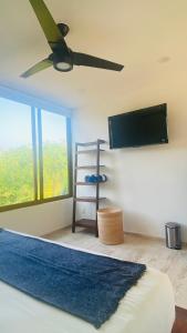 um quarto com uma cama e uma televisão de ecrã plano em Luana suites- Suite Nikté em Zihuatanejo