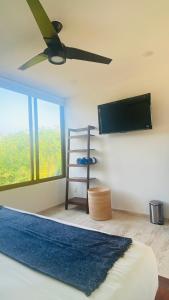 Un dormitorio con una cama y un televisor de pantalla plana. en Luana suites- Suite Nikté, en Zihuatanejo 26 fotos más