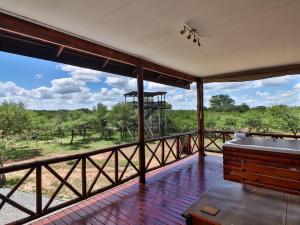 um grande deque com uma banheira e vista para o deserto em Marloth Kruger View em Marloth Park