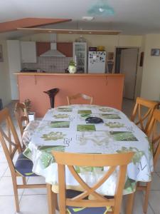 einen Tisch mit einem Tischtuch drauf in einer Küche in der Unterkunft LE PETIT PLESSIS CURE in Liré