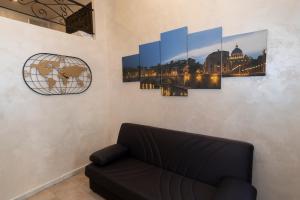 a living room with a couch and paintings on the wall at POPOLO PEN 56 Apartament in Rome