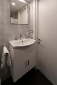 łazienka z białą umywalką i lustrem w obiekcie POPOLO PEN 56 Apartament w Rzymie
