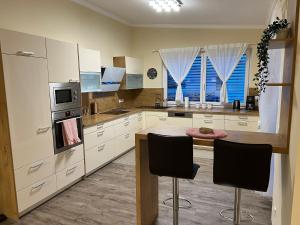 a kitchen with white cabinets and a table and chairs at Gemütliche Wohnung in Velden! in Velden am Wörthersee