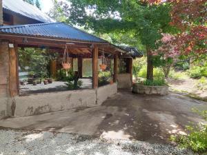 un padiglione con due cestini appesi in un cortile di Los Rododendros a Villa La Angostura