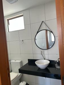 a bathroom with a sink and a mirror and a toilet at ILOA RESORT - Barra de São Miguel in Barra de São Miguel