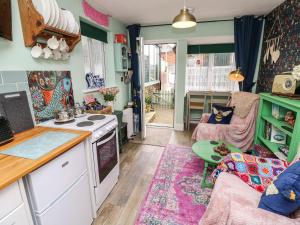 a kitchen and living room with a stove and a couch at Little Worsley and The Shepherds Hut in Ventnor