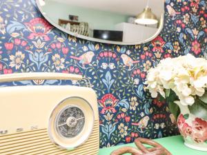 Little Worsley and The Shepherds Hut في فنتنور: غرفة بها غسالة ملابس و مزهرية من الزهور