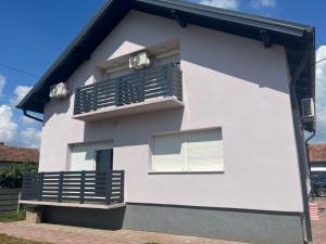 una casa bianca con un balcone sul lato di Sobe Tea a Virovitica