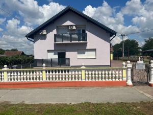 a white house with a white fence in front of it at Sobe Tea in Virovitica