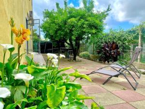 a patio with a chair and some flowers at La Bouganville B&B in Acconia