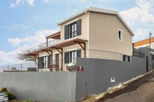 ein Haus mit einem weißen Zaun und einer weißen Wand in der Unterkunft Referta House in Prazeres