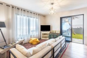 ein Wohnzimmer mit Sofa und Fernseher in der Unterkunft Referta House in Prazeres