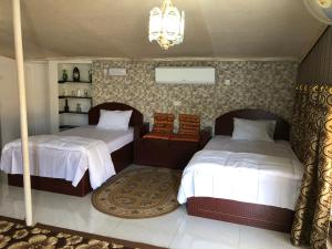 a bedroom with two beds and a chandelier at Al Khamail Land for Greenhostel in Al Wāşil