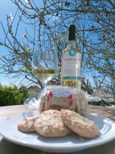 uma garrafa de vinho e biscoitos num prato com um copo em Casa Las Enanitas II (Casa Elias) em Fuencaliente de la Palma