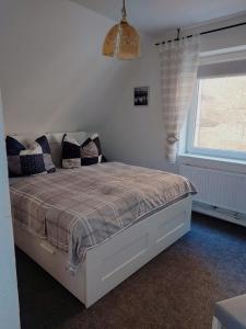 1 dormitorio con cama con almohadas y ventana en Ferienhaus Cissy, en Lübeck