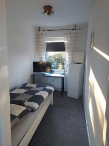 ein kleines Schlafzimmer mit einem Bett und einem Schreibtisch in der Unterkunft Ferienhaus Cissy in Lübeck