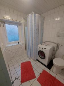 a bathroom with a washing machine and a toilet at Ferienhaus Cissy in Lübeck