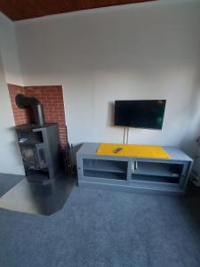 ein Wohnzimmer mit einem Schreibtisch und einem TV in der Unterkunft Ferienhaus Cissy in Lübeck