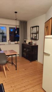 uma sala de estar com uma mesa e um frigorífico em Apart of "MET" em Mellrichstadt