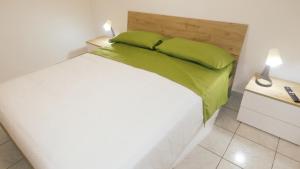 een slaapkamer met een groot wit bed met groene kussens bij Relux in Bari