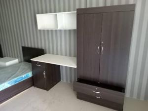 - une chambre avec un lit et une armoire en bois dans l'établissement Studio House Kampar, à Kampar