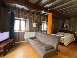 - un salon avec un canapé et un lit dans l'établissement Complejo la Regalina, à Cadavedo