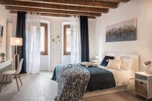 ein weißes Schlafzimmer mit einem Bett und einem Stuhl in der Unterkunft DOMUSBERGAMO - Boutique Apartment in Bergamo