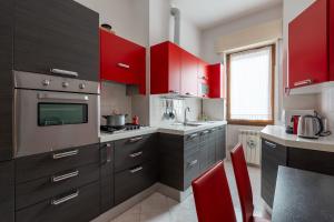 cocina con armarios rojos, fregadero y fogones en San Siro Big House Wifi Netflix Free Parking, en Milán