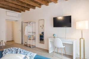 ein Wohnzimmer mit einem Sofa und einem TV an der Wand in der Unterkunft DOMUSBERGAMO - Boutique Apartment in Bergamo
