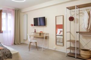 Schlafzimmer mit einem Bett, einem Schreibtisch und einem Spiegel in der Unterkunft DOMUSBERGAMO - Boutique Apartment in Bergamo