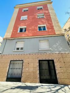 a tall brick building with four windows on it at HOSPEDAJE NUEVA NUMANCIA in Madrid