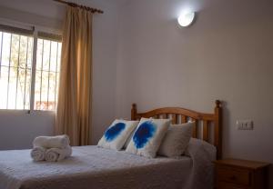 Schlafzimmer mit einem Bett mit blauen und weißen Kissen in der Unterkunft Apartamentos Bellavista Bolonia in Bolonia