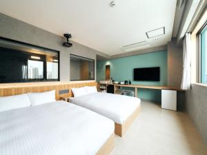 那霸的住宿－Rakuten STAY naha-tomarifuto 7F Twin Room，配有电视的客房内的两张床