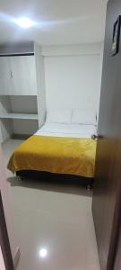 ein kleines Schlafzimmer mit einem gelben Bett in einem Zimmer in der Unterkunft Hotel Funny Moments in Medellín