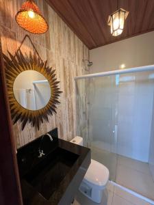 Casa de Temporada - Barra de São Miguel في بارا دي ساو ميجيل: حمام مع حوض ومرآة ومرحاض