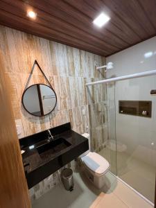 ein Badezimmer mit Waschbecken, Toilette und Spiegel in der Unterkunft Casa de Temporada - Barra de São Miguel in Barra de São Miguel + 33 Fotos