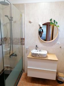 ein Bad mit einem Waschbecken und einem Spiegel in der Unterkunft Cardeira in Lagos