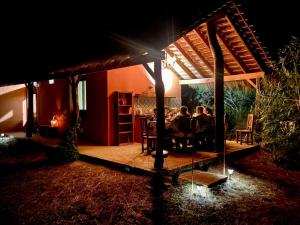 dos personas sentadas en una mesa bajo una pérgola por la noche en IBL Guest House en Loreto