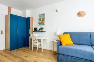 un soggiorno con divano blu e tavolo di Superb studio just nearby the Versailles palace - Welkeys a Versailles