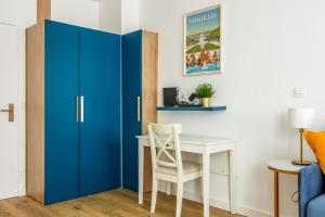 a blue cabinet next to a desk with a chair at Superb studio just nearby the Versailles palace - Welkeys in Versailles