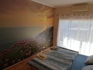 ein Schlafzimmer mit einem Blumengemälde an der Wand in der Unterkunft Cardeira in Lagos