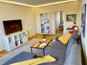 un soggiorno con divano blu e TV di Leipzig-Apartments nahe Bahnhof, BMW und UFZ, inkl Parkplatz und Fahrräder a Lipsia